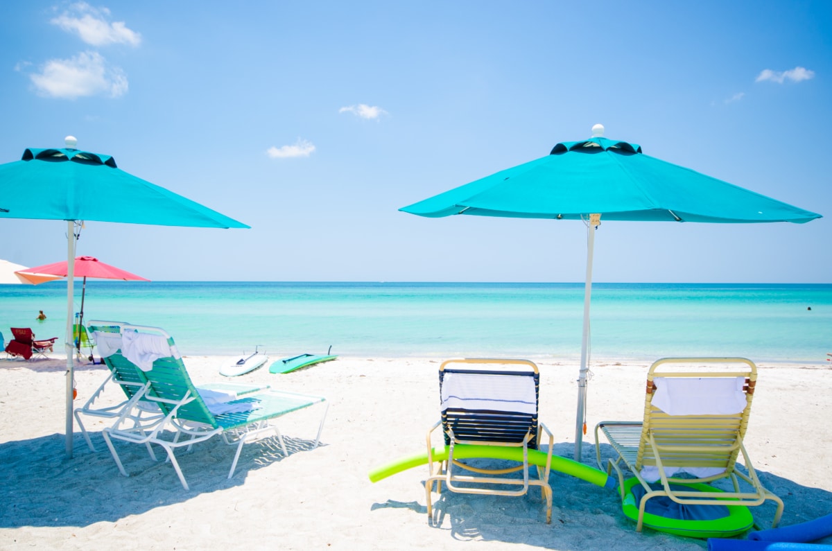 Turquoise umbrellas and lounge chairs on the white sand at Casa Del Mar